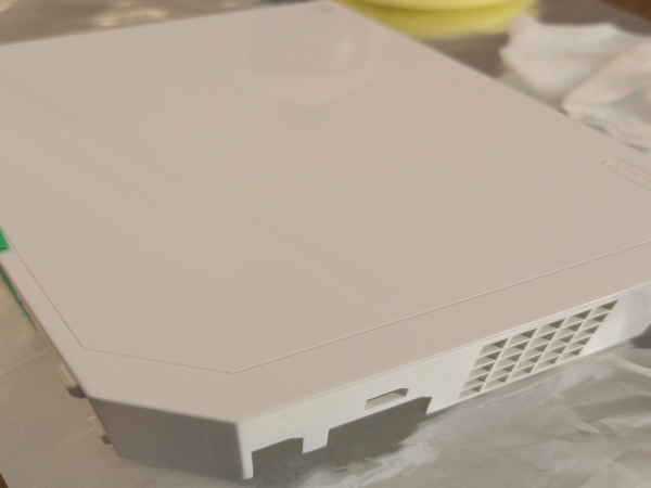 A photograph, of a OEM white Nintendo Wii case being restored.